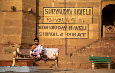 Man sitting on bench in city