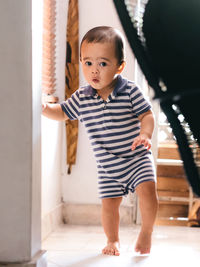 Full length of boy standing against wall