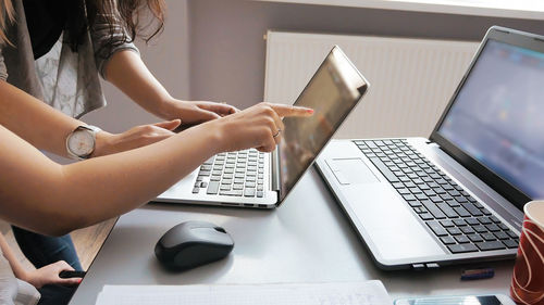 Businesswomen working over laptop at desk in office