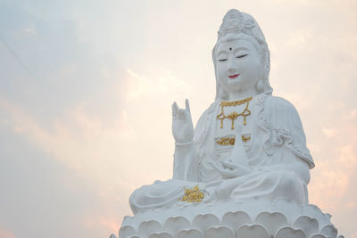 Low angle view of statue against temple against sky
