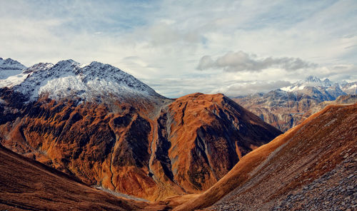 Scenic view of snowcapped mountain against cloudy sky