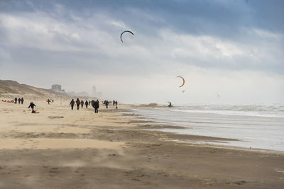 People on beach against sky