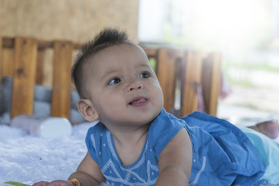 Cute baby wearing lying on belly in nursery room.