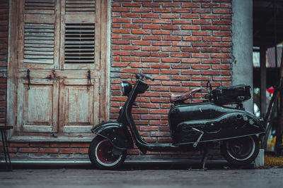 Bicycle parked against brick wall of building