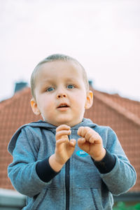 Portrait of cute girl with arms crossed standing outdoors