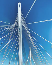 Low angle view of suspension bridge against blue sky