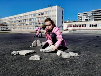 Portrait of young man sitting on street