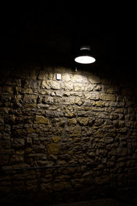 Close-up of illuminated light bulb on wall