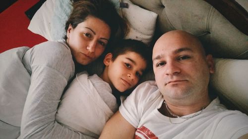 Portrait of family relaxing on bed at home