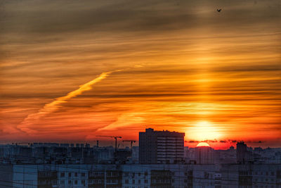 Buildings in city against sky during sunset