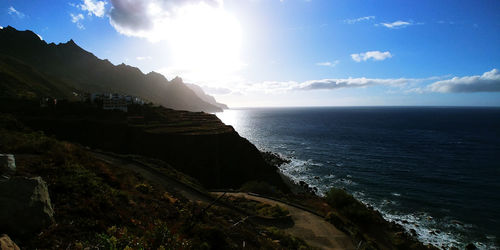 Scenic view of sea and mountains against sky