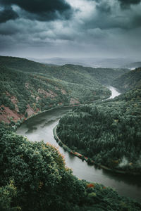 High angle view of river amidst trees against sky