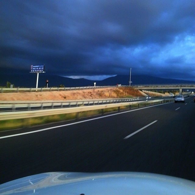 transportation, sky, cloud - sky, road, road marking, cloudy, car, the way forward, mode of transport, cloud, land vehicle, highway, street light, weather, street, storm cloud, bridge - man made structure, on the move, illuminated, overcast