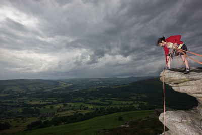 Female rock climber on cliff at the peak district in england