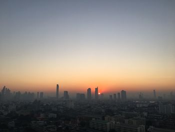 Modern buildings against sky during sunrise