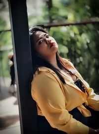 Woman looking up while standing outdoors