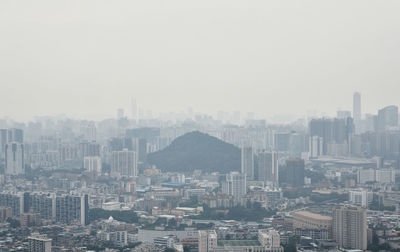 Aerial view of buildings in city against sky