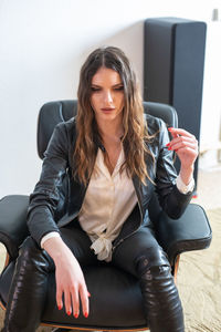 Young woman sitting on chair at home