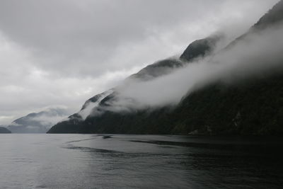 Scenic view of sea and mountains against sky