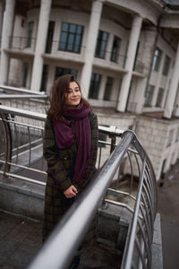 Portrait of beautiful young woman standing in the city and smiling