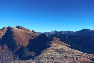 Scenic view of mountains against clear blue sky