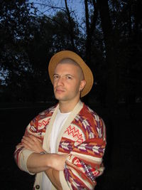 Portrait of young man standing against trees