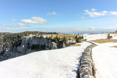 Scenic view of snow covered land against sky