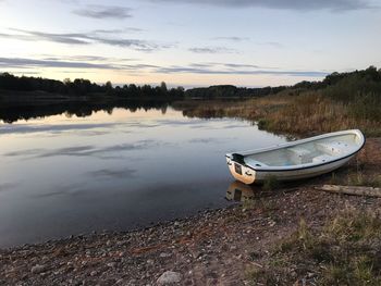 Boat moored on beach against sky