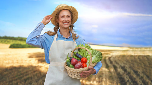 Young woman holding ice cream cone in field