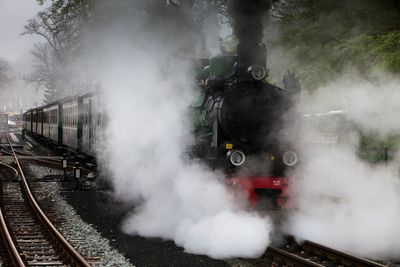 Smoke coming out from steam train on railroad tracks