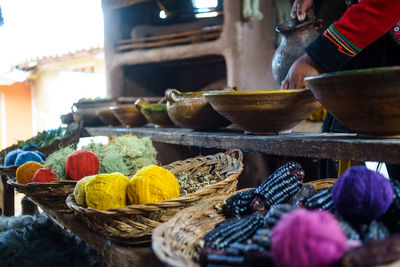 Colorful ball of wools in wicker basket on table