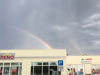 Rainbow over city against sky