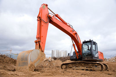 Red excavator during earthworks at construction site. backhoe digging the ground for the foundation