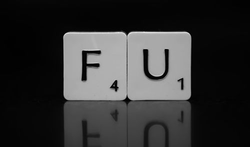 Close-up of scrabble tiles on table with reflection