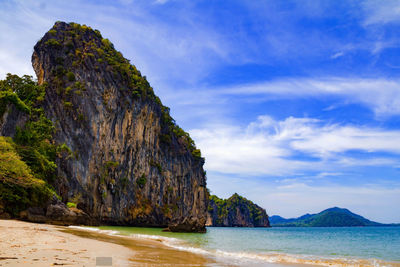 Rock formation on beach against sky