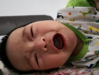 Close-up portrait of baby girl sleeping on bed