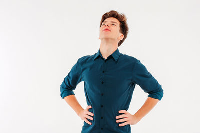 Low angle view of young man standing against white background