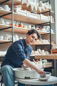 A young brunette potter at a potter's wheel