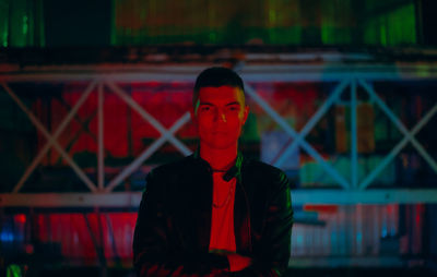 Portrait of young man standing against wall