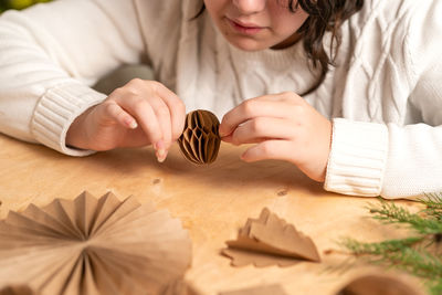 High angle view of woman holding seashell on table