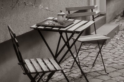 High angle view of empty chairs and table against building