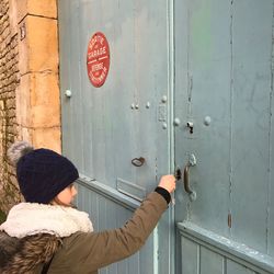 Side view of girl opening door