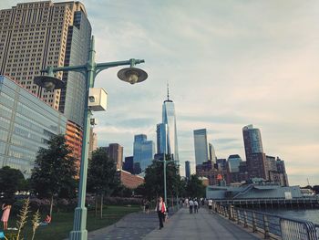 Buildings in city against cloudy sky