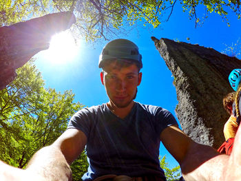 Portrait of young man against trees