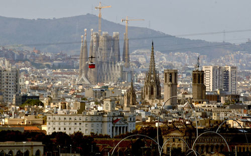 Aerial view of buildings in city against sky