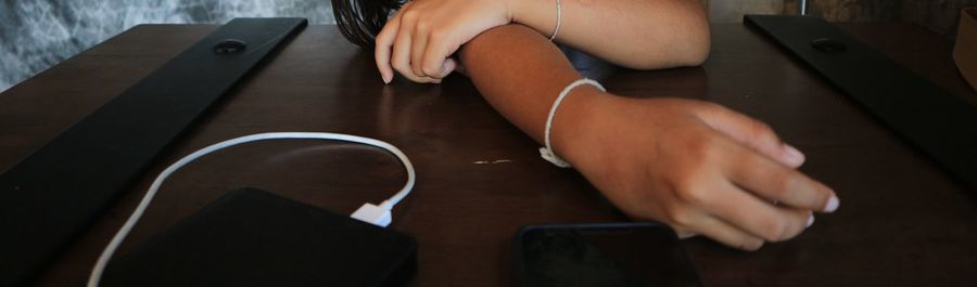 Cropped image of woman sitting by desk