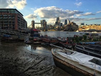 Boats moored on sea against sky in city