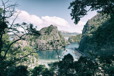 Scenic view of lake by trees against sky