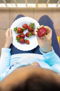 Midsection of woman holding strawberries