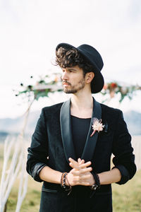 Portrait of young man standing against sky